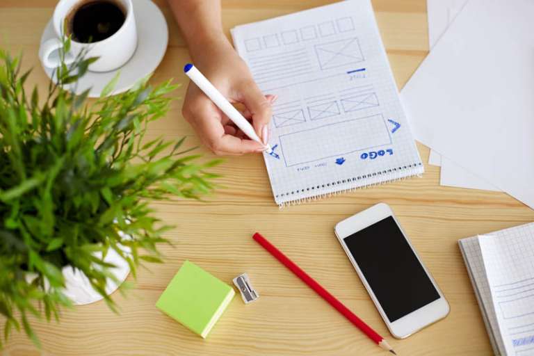 Woman sketching on paper web design in office